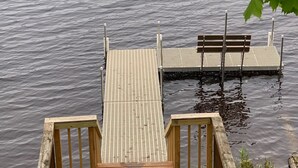 Un muelle de madera que lleva a un espigón con un banco.