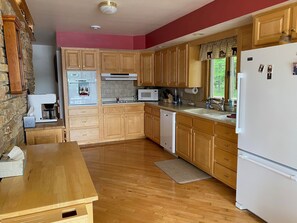 Enjoy cooking in this kitchen with microwave and dishwasher, and dine at the nearby table with a view of the surrounding greenery.