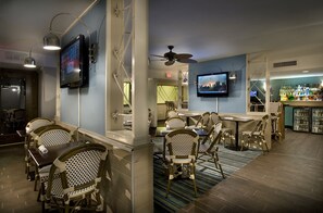 A bar area with wicker chairs, a television mounted on the wall, and a ceiling fan. - Premium Ocean View Two Bedroom Condo - FREE Pickleball 5 minutes away! (Myrtle Beach)