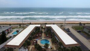 A hotel with a rooftop pool, a beach view, and a parking area. - OCEAN VIEW CONDO w/ Pool, Cable, Wifi, BEACH ACCESS. Ormond-by-the-Sea  (Ormond Beach)