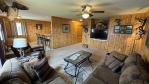 A living room with a sofa, coffee table, and a ceiling fan. - 40 Creek Lodge South at Waubay Lake (Grenville)