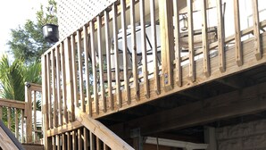 Un escalier en bois avec une rampe, menant à un balcon.