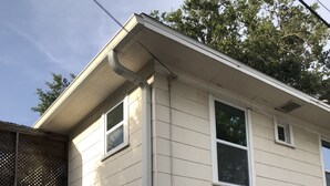 Une maison à deux étages avec un garage, une façade en pierre et le numéro « 108 1/2 » sur le côté.