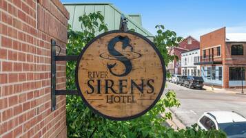 Uma placa de madeira para o Hotel River Sirens.