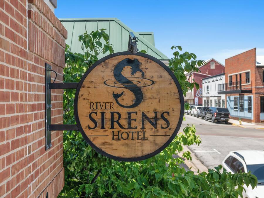Un letrero de madera del Hotel River Sirens.