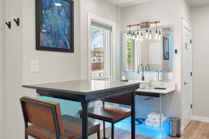 Una cocina moderna con una isla grande, un comedor con sillas y vistas al exterior.
