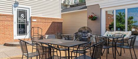 A River Sirens Hotel courtyard with outdoor seating and a brick wall.