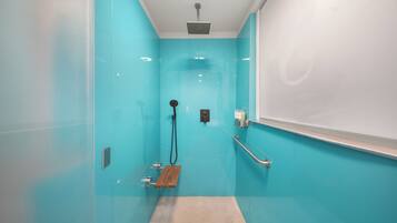 Une salle de bain moderne avec une douche à parois de verre, un pommeau de douche à main, une porte de douche en verre, une cabine de douche en verre.