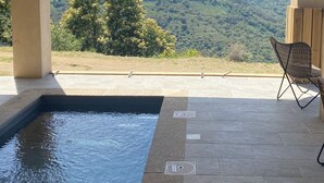 Ein Poolbereich mit Blick auf Berge und ein Stuhl.