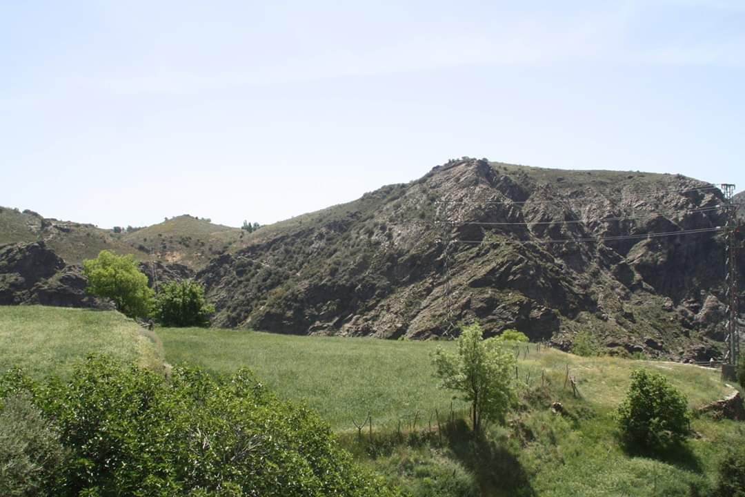 Eine gebirgige Landschaft unter blauem Himmel.