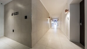 A modern hotel corridor with a tiled floor, a long hallway, and a door marked with the number 609.