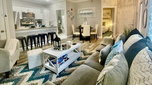 Una sala de estar moderna con un sofá, una mesa de centro y un comedor con sillas y una mesa.