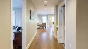 A hallway with wooden flooring, white walls, and recessed lighting. - Downtown Getaway (Caseville)