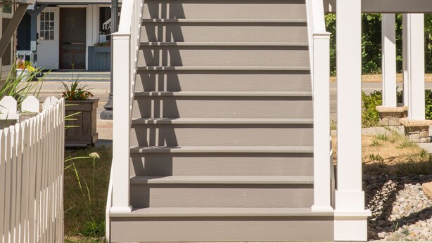 A staircase with white railings leading to a covered area. - Downtown Getaway (Caseville)