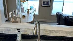 A kitchen with a stainless steel sink, a bottle of soap, and a dining area with a table and chairs. - View are amazing that is what our guests say
5 Minutes to the Freeway and town (Rush City)