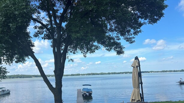 A deck with chairs and an umbrella overlooking a lake with boats and a distant shoreline. - View are amazing that is what our guests say
5 Minutes to the Freeway and town (Rush City)