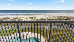 A balcony with a view of a beach and a swimming pool. - Jacksonville Beachdrifter by Distinctive Beach Rentals (Jacksonville Beach)