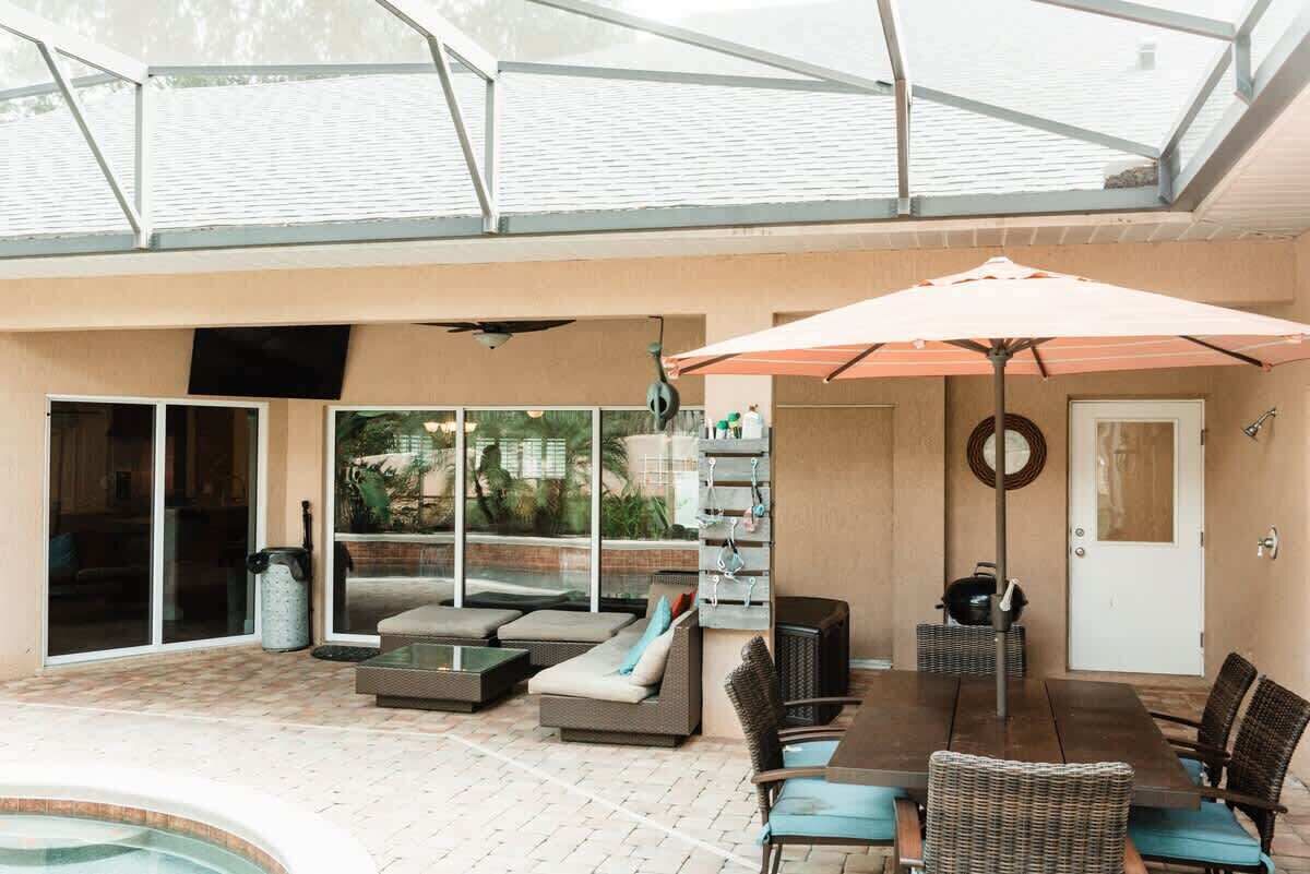 Eine Außenpatio mit Pool, Sitzbereich und überdachtem Essbereich.