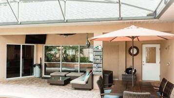 Eine Außenpatio mit Pool, Sitzbereich und überdachtem Essbereich.