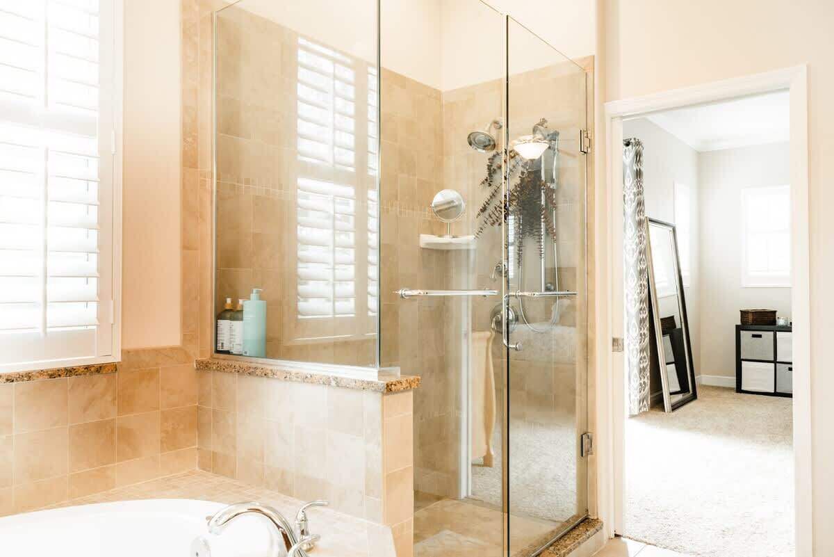 A modern bathroom with a glass-enclosed shower, a freestanding bathtub, and a vanity with a mirror.