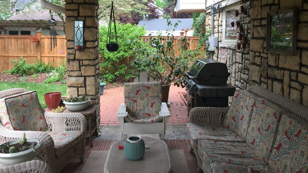 A covered patio with wicker furniture, a grill, and potted plants. - 3 Bedroom Home in the Highlands, close to everything (Louisville)