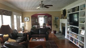 A living room with leather sofas, a coffee table, a bookshelf, and a television. - 3 Bedroom Home in the Highlands, close to everything (Louisville)