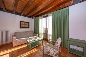 A living room with a sofa, a floral chair, a coffee table, and a green side table.