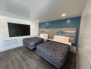 A room with two beds, a large window, a wall-mounted air conditioner, and a beach-themed mural on the wall. - Travel Inn Motel (Anaheim)