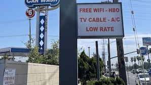 Schild für das Travel Inn Motel mit Whirlpoolzimmer, kostenlosem WLAN, HBO, Klimaanlage und günstigen Preisen.