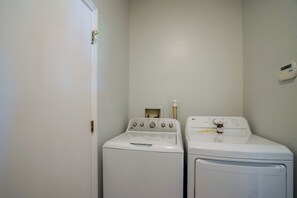 A laundry room with two white front-loading washing machines and a dryer.
