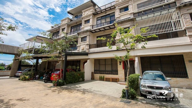 A multi-story residential building with a covered parking area, a balcony, and a car parked in the driveway. - Wild Fun Hualien (Ji'an)