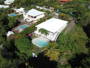 An aerial view of a residential area with multiple houses, a swimming pool, and lush greenery. - Villa with private lagoon pool - Tropical garden & absolute calm in Le Diamant (Le Diamant)