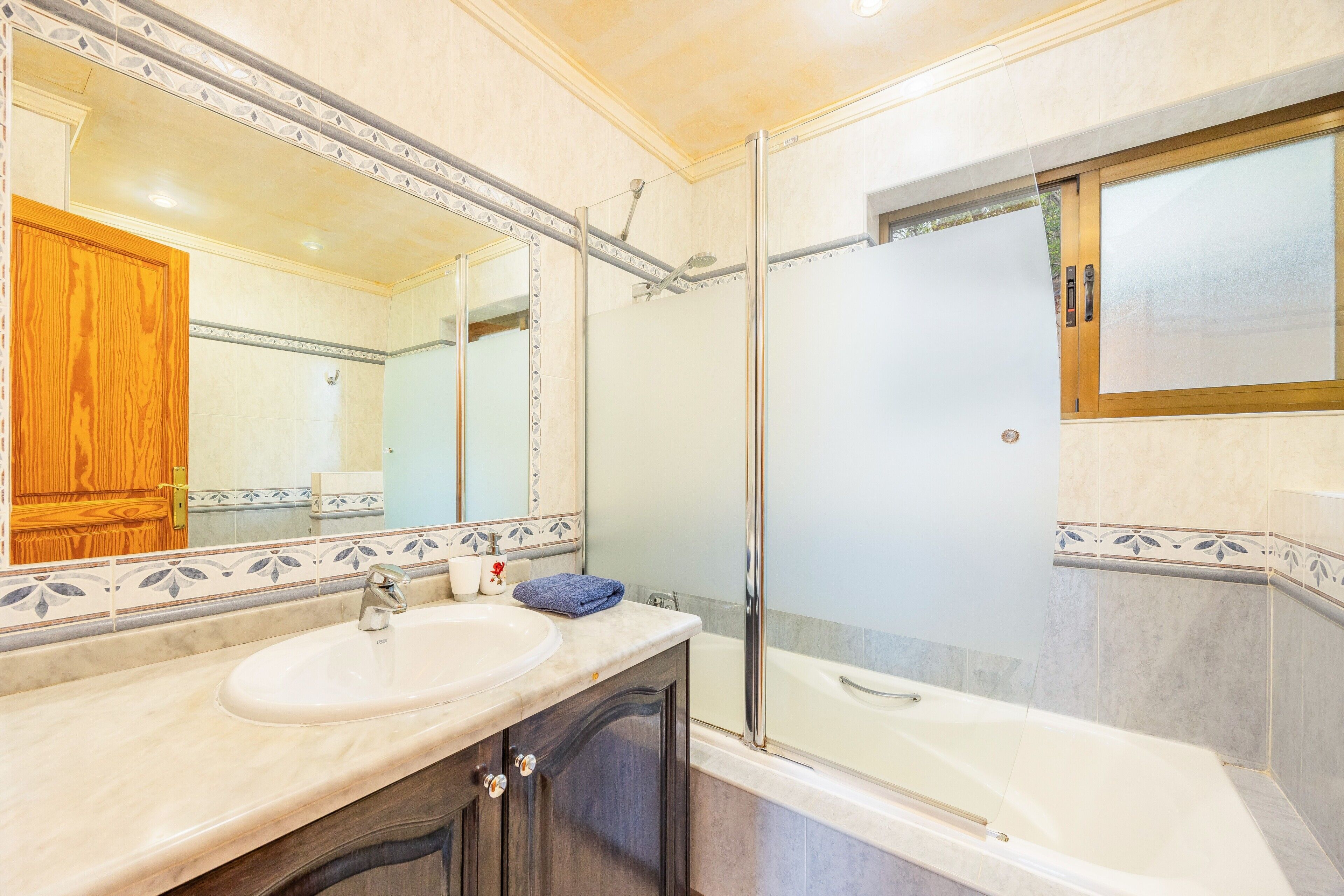 Un baño con lavamanos, espejo, ducha y bañera.