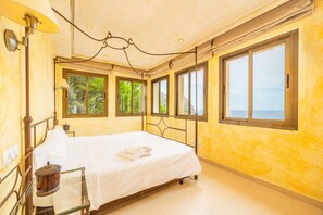 A room with a bed, large windows, and a view of the sea. - Villa "Cala Llamp" with Panoramic Sea Views (PORT ANDRATX)