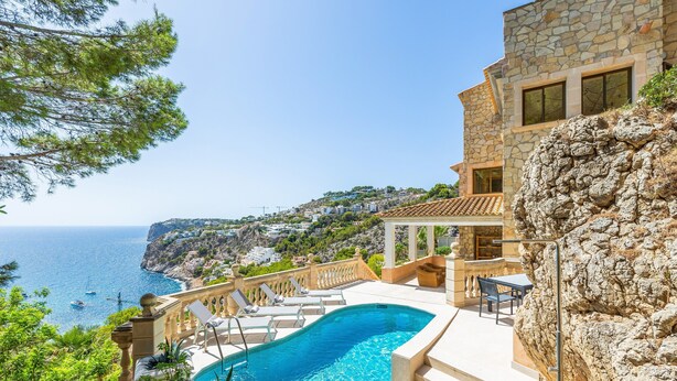 A swimming pool with a view of the sea, stone building, and outdoor seating area. - Villa "Cala Llamp" with Panoramic Sea Views (PORT ANDRATX)