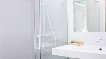 Eenvoudige kamer | Badkamer | Een douche, een haardroger, handdoeken, zeep