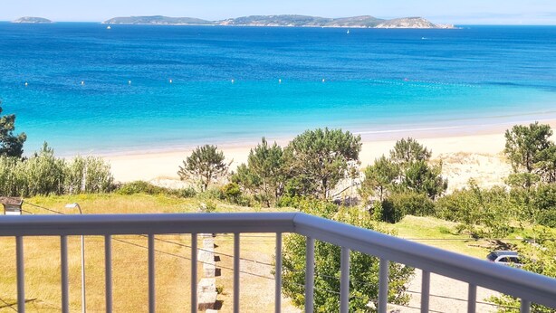 A coastal view from a balcony with a clear blue sea, sandy beach, and distant islands. - Hotel Mar Azul (Sanxenxo)