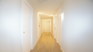 A narrow, well-lit hallway with wooden flooring and white walls. - Hotel Mar Azul (Sanxenxo)