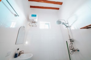 A bathroom with a white sink, a handheld showerhead, a window, and a soap dispenser. - Simba Apartment Hotel (Bwejuu)