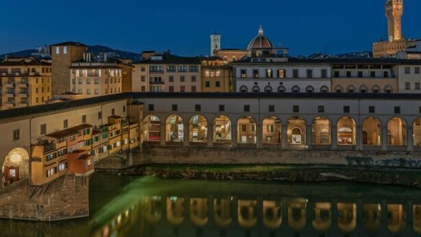 Edificio histórico con ventanas de arco y un río al frente.