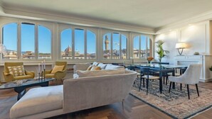 Un amplio espacio de sala con un ventanal grande, una mesa de comedor y un sofá.