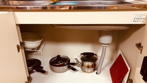 Une cuisine équipée d’un évier, d’une cuisinière et de divers ustensiles.