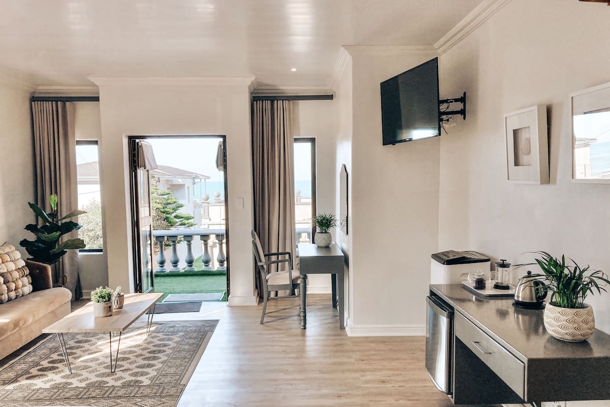 Un salon moderne avec un canapé, une table basse et une vue sur l’extérieur.