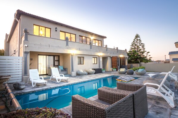 Alberca al aire libre y camastros 