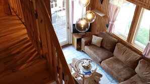 Un intérieur en bois avec un escalier, un canapé et une table.