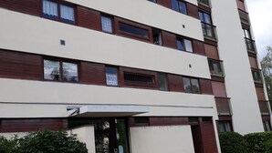 Un immeuble résidentiel à plusieurs étages, doté d’une façade sobre, de balcons et d’une entrée sécurisée par un portail.