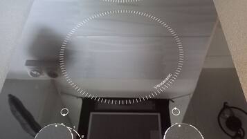 Eine Küche mit einer digitalen Kochplatte, zwei Bedienelementen und einem digitalen Display.