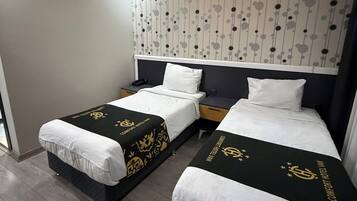 Habitación de hotel con dos camas, diseño moderno y papel tapiz estampado.