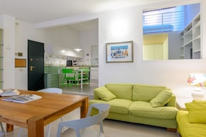 Cozy living space with a dining table, sofa, and kitchen area.