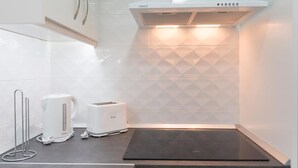 Una cocina moderna con estufa integrada, tostadora y hervidor sobre la encimera.